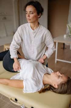 Therapist conducting chiropractic treatment on a patient indoors. osteopath or chiropractor for back pain back pain what to do
