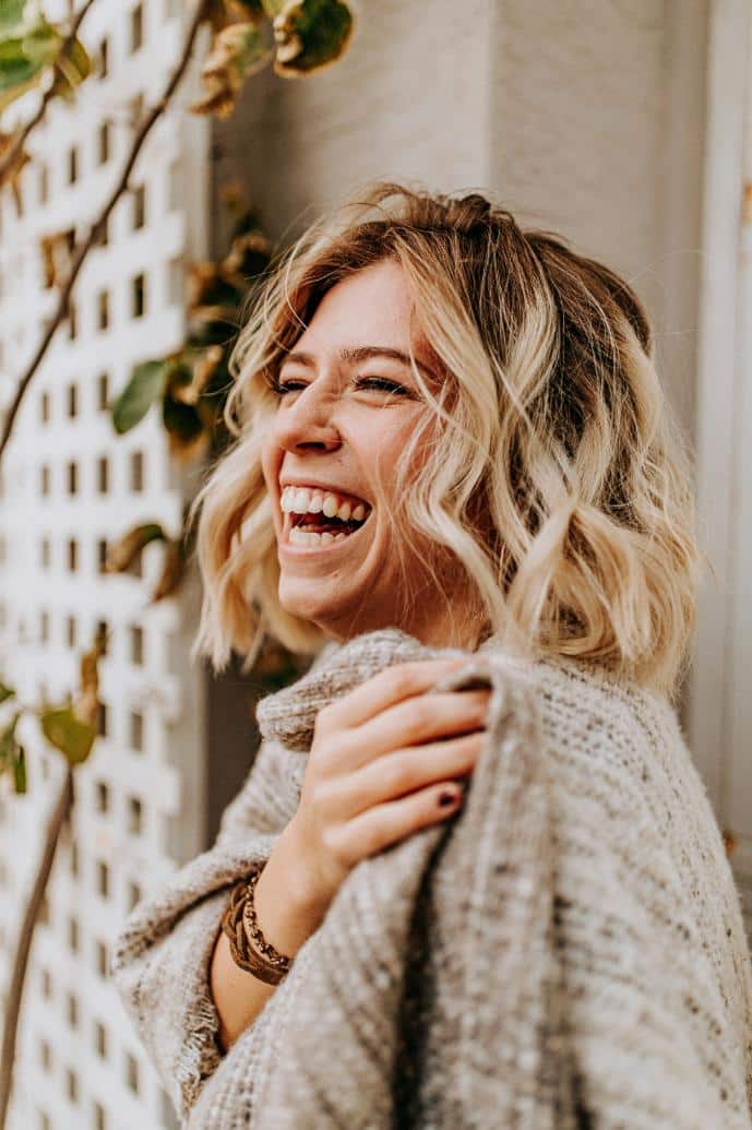 Une femme joyeuse exprime et se libère de ses émotions par le coaching en santé holistique et coaching libération émotionnelle